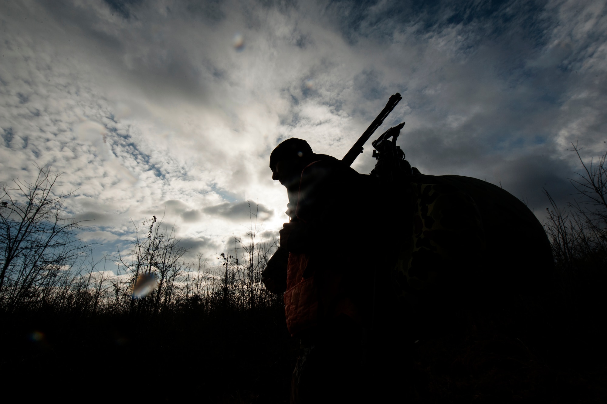 Chaplain Capt. Matthew Spencer walks through a field to his hunting stand Dec. 14, 2014, at Little Rock Air Force Base, Ark. Spencer’s hunt was unsuccessful at yielding game this rainy morning. (U.S. Air Force photo by Senior Airman Kaylee Clark)