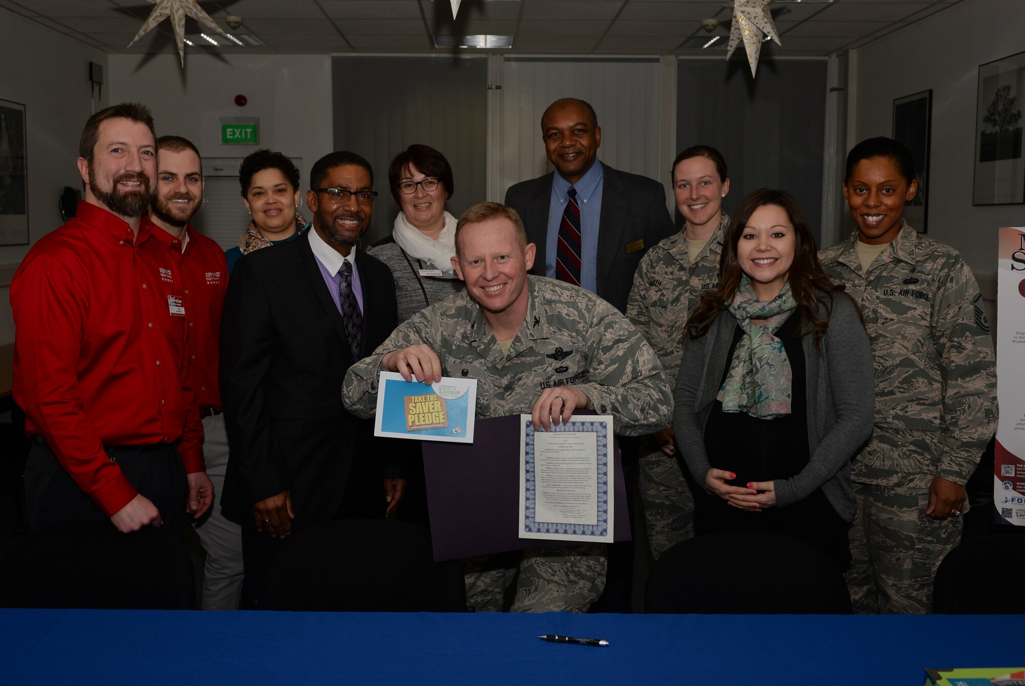 U.S. Air Force Col. Joe McFall, 52nd Fighter Wing commander, center, holds up a proclamation and pledge card alongside members of the Spangdahlem community during a Military Saves Week proclamation signing at the Airman & Family Readiness Center at Spangdahlem Air Base, Germany, Feb. 19, 2015. The proclamation designated Feb. 23-27, 2015, as Military Saves Week, an awareness campaign aimed at promoting financial security amongst active-duty service members and their families. (U.S. Air Force photo by Staff Sgt. Joe W. McFadden/Released)