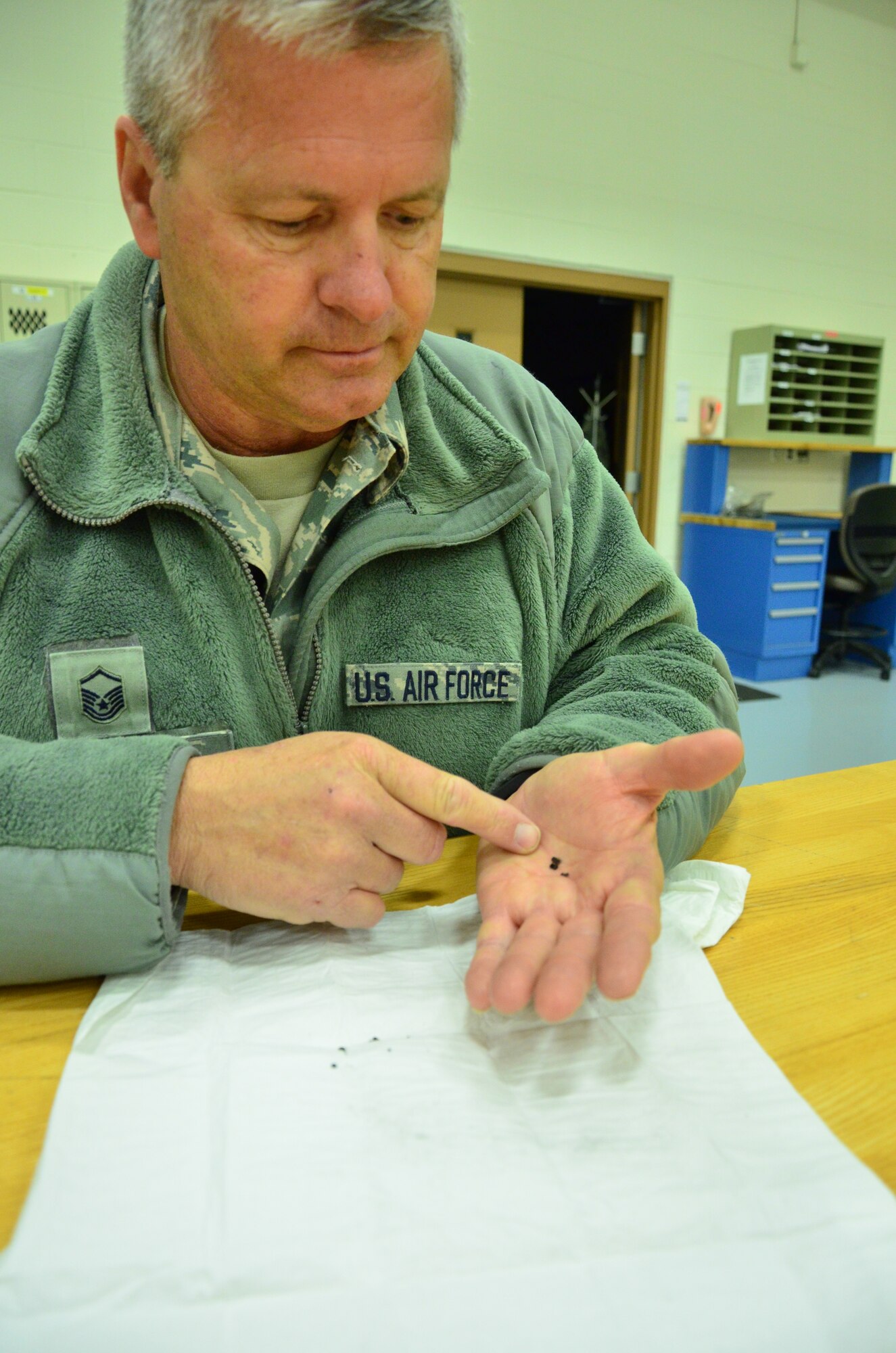 Master Sgt. James Rials, a crew chief with the 403rd Aircraft Maintenance Squadron inspects the sediment from the corrosion that affected the pressurization a C-130J aircraft at Keesler Air Force Base, 10 Feb. (U.S. Air Force Photo/Master Sgt. Brian Lamar) 
