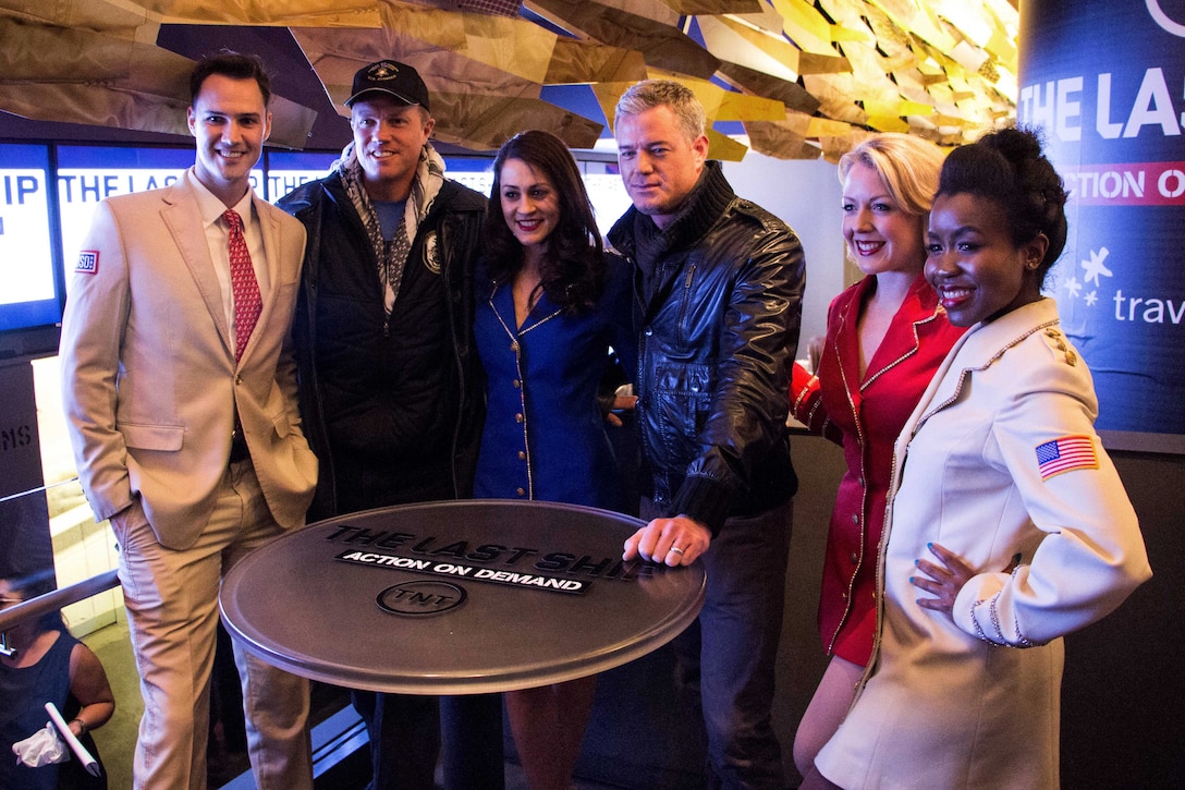 Adam Baldwin, second from left, and Eric Dane, center right, pose for a photo with the USO Show Troupe at the TV show's NBA All Star game party at Clyde Frazier's in New York City, Feb. 15, 2015.