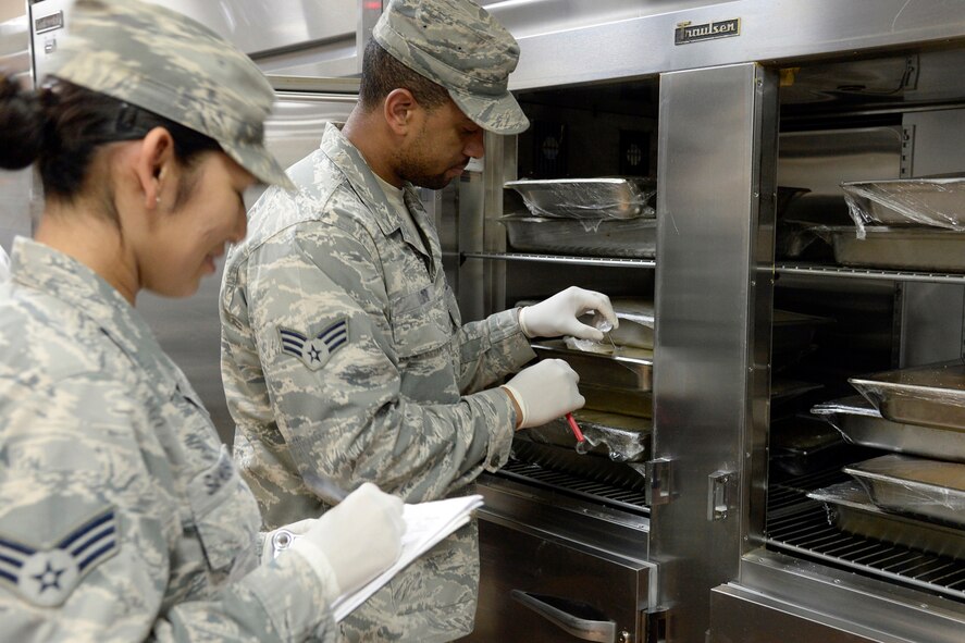 Senior Airman Jovitamaria, left, and Senior Airman Sterling, Oasis quality assurance, perform a QA inspection on the food in the dining facility at an undisclosed location in Southwest Asia Feb. 17, 2015. From the dining room and kitchen to the outside rations warehouse, the Airmen at the Oasis ensure that food security remains their primary mission. Jovitamaria is currently deployed from Beale Air Force Base, Calif., and is a native of San Diego, Calif. Sterling is currently deployed from Beale AFB, Calif., and is a native of Saint Louis, Mo. (U.S. Air Force photo/Tech. Sgt. Marie Brown)