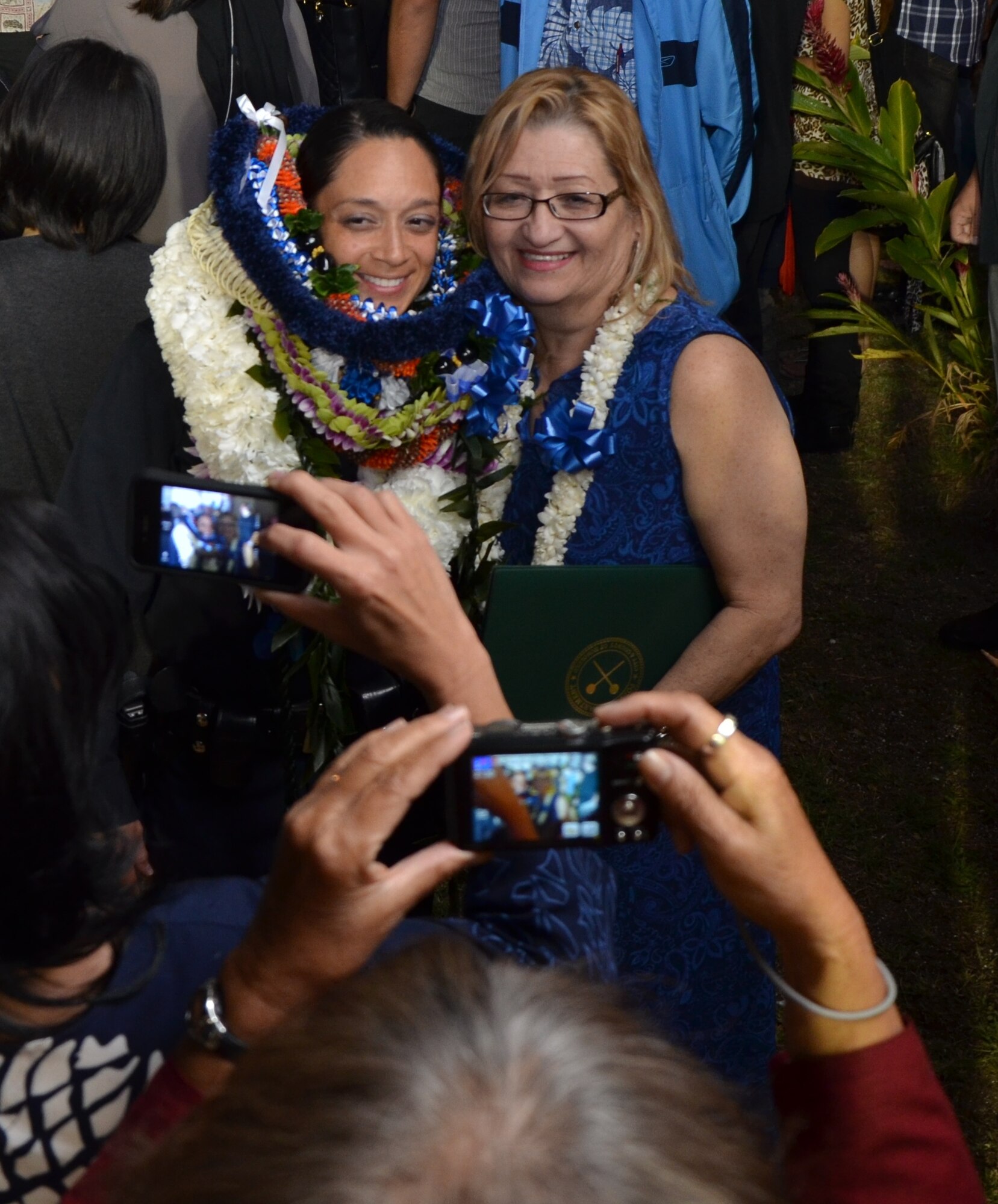 Tech. Sgt. Celsa Salazar, left, a personnelist with the 624th Regional Support Group, Joint Base Pearl Harbor-Hickam, Hawaii, poses for a photo with a family member, right, after graduating from the Honolulu Police Department Training Academy as a member of the 178th recruit class at a ceremony held at the McKinley High School auditorium, Honolulu, Feb. 11. (U.S. Air Force photo by Tech. Sgt. Phyllis Keith)
