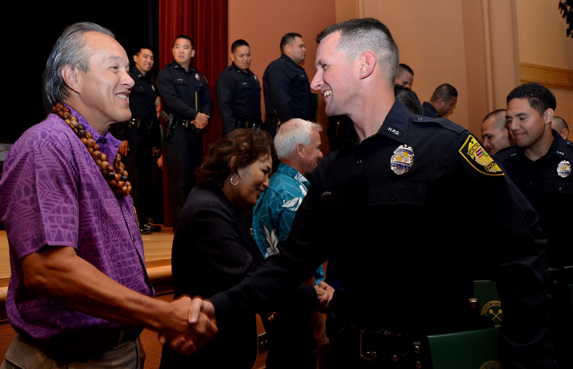 Tech. Sgt. Justin Smith, right, an air transportation specialist with the 48th Aerial Port Squadron, shakes hands with Max Sword, left, police commissioner with the Honolulu Police Department (HPD) after a graduation ceremony for HPD's 178th recruit class held at the McKinley High School auditorium, Honolulu, Hawaii, Feb. 11. Smith said he had always wanted to be a police officer and finally took advantage of the opportunity to serve his community while serving his country as a reservist. (U.S. Air Force photo by Tech. Sgt. Phyllis Keith)