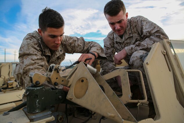 Lance Cpl. Bradley W. Walsh (Left) and Lance Cpl. Colin M. Weathers work on the mount for an M240B medium machine gun Jan. 18 at Marine Air Ground Combat Center Twentynine Palms, California, during Integrated Training Exercise 2-15. Walsh and Weathers have been training with the jump team since arriving at Twentynine Palms in early January. Walsh, a rifleman, is the assistant convoy commander for the jump team. Weathers, a rifleman, is a gunner for one of the vehicles in the jump team. Both Marines are with Headquarters Company, 4th Marine Regiment, 3rd Marine Division, III Marine Expeditionary Force. 