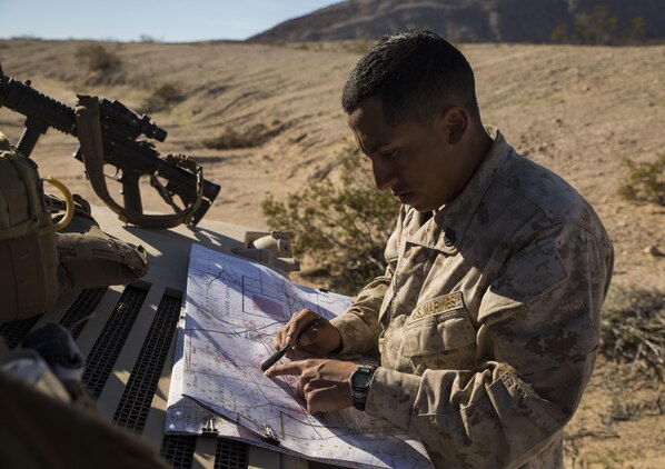Staff Sgt. Absalon A. Cabrera plots points on a map to designate the best route to transport the commanding officer for Special Purpose Marine Air-Ground Task Force Four Feb. 13 at Marine Air Ground Combat Center Twentynine Palms, California, during the battalion assault course as part of Integrated Training Exercise 2-15. Cabrera takes personal time from his day to teach the Marines with the jump team how intermediate map techniques and other skills to increase the jump team’s capabilities. ITX 2-15 is designed to integrate combined arms and improve warfighting capabilities. Cabrera, a Los Angeles, California, native and infantry unit leader, is the jump team commander for Special Purpose Marine Air-Ground Task Force Four with Headquarters Company, 4th Marine Regiment, 3rd Marine Division, III Marine Expeditionary Force. 