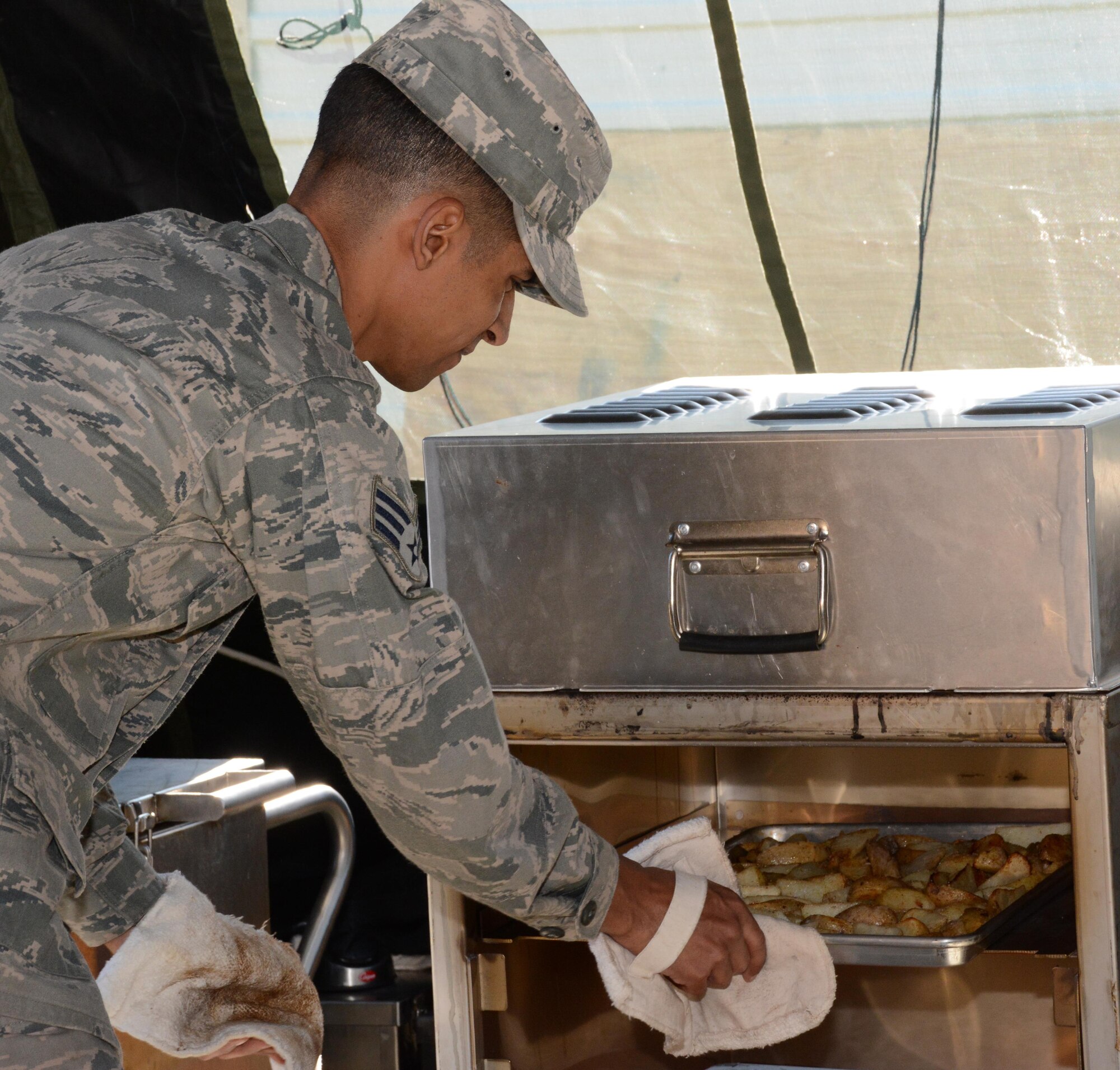 Senior Airman Angel Agosto, 301st Services Flight food operations journeyman, checks the potato fries Feb. 7 during the food prep portion of the 2015 Air Force Reserve Command’s Hennessy competition here. While competing for their second consecutive trophy, the 10-person team formed a single pallet expeditionary kitchen (SPEK) then served 165 Airmen lunch. (U.S. Air Force photo by Staff Sgt. Samantha Mathison)
