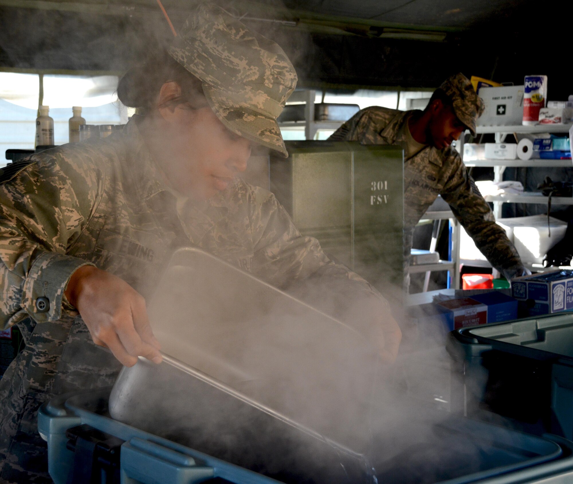 Staff Sgt. Kimberlee Ewing, 301st Services Flight sustainment services technician, pours water in the food warmers and preps for lunch Feb. 7 during the 2015 Air Force Reserve Command’s Hennessy competition here. While competing for their second Hennessy trophy, the 10-person team formed a single pallet expeditionary kitchen (SPEK) then served 165 Airmen lunch. (U.S. Air Force photo by Staff Sgt. Samantha Mathison)
