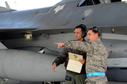 Maj. Juan Gonzalez, left, a Colombia air force maintenance officer, receives a flightline orientation from U.S. Air Force Tech. Sgt. Michael Hernandez, an F-16 crew chief with the 495th Fighter Group, Det 157 at McEntire Joint National Guard Base, S.C., during a visit to the base Feb. 20, 2015. The visit was the latest engagement for the State Partnership Program between South Carolina and the Republic of Colombia. 