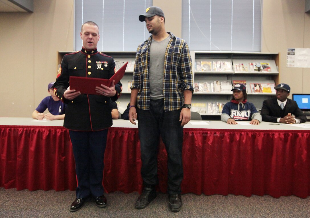 Rob Dowdy, an offensive lineman from Westerville South High School football team, received a certificate of participation from Sgt. Cordy Ford, a Recruiting Station Charleston recruiter, for playing in the Marine Corps Semper Fidelis Bowl, Jan 4, 2015, at Westerville South High School in Westerville, Ohio. Dowdy signed to play at the University of West Virginia, Feb.  4, 2015.
Photo by: Fred Squillante, Columbus Dispatch photographer
