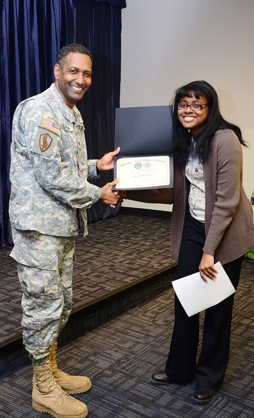 Col. Jeremy Martin, Defense Information School commandant, presents Rachel M. Martin, a Fort Meade High School student, with her third place award during the Martin Luther King, Jr. observance, Fort Meade, Md. Jan 28. 
The observance, hosted by the DINFOS Equal Opportunity committee, provided music, poetry and education for service members and civilians at the school.
