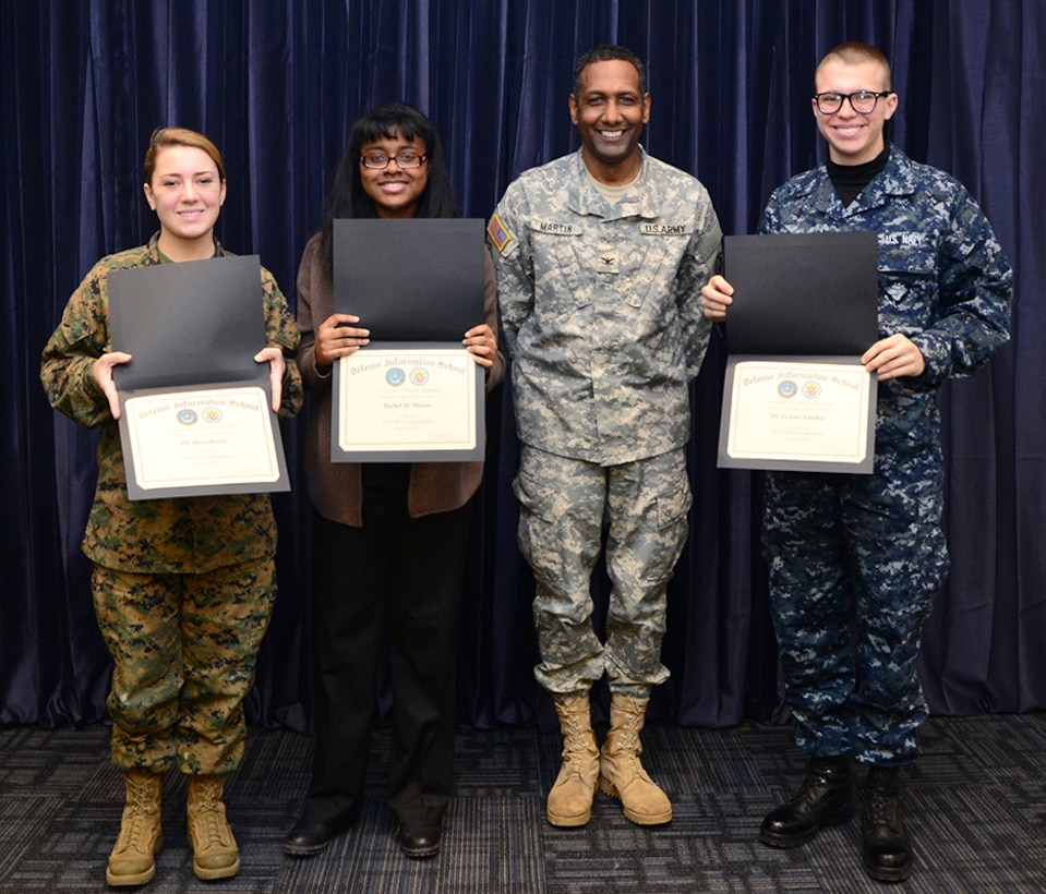 Col. Jeremy Martin, Defense Information School commandant, presents certificates to the winners of the Martin Luther King, Jr. poetry contest to Pfc. Alexis Rocha, DINFOS student and second place winner, Rachel M. Martin, a Fort Meade High School student and third place winner, and Seaman Zackary Landers, DINFOS student and first place winner, Fort Meade, Md., Jan. 28, 2015. The observance, hosted by the DINFOS Equal Opportunity committee, provided music, poetry and education for service members and civilians at the school. (DoD photo by Staff Sgt. David Chapman/Released) 