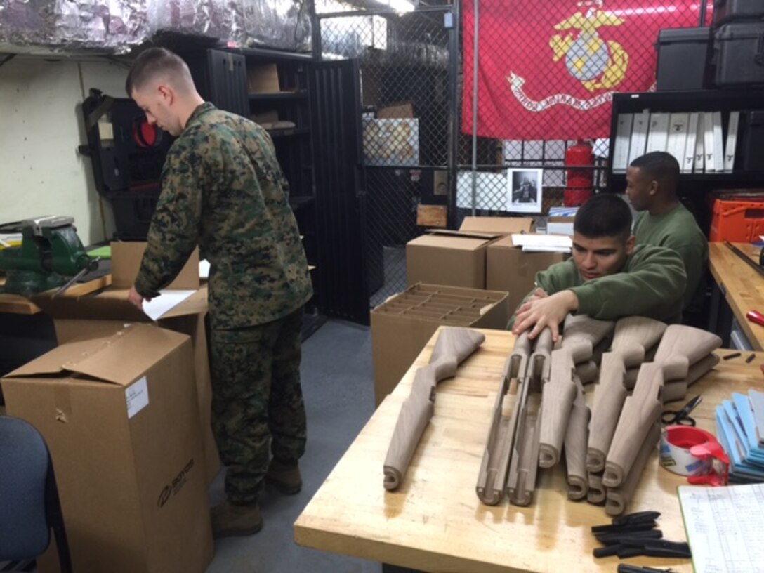 Cpl. Micah Rissler, Lance Cpl. Marcus Allen, and Lance Cpl. Jose Rodriguez serialize M1 Garand wooden stocks at the Marine Barracks Washington, D.C. armory. 
