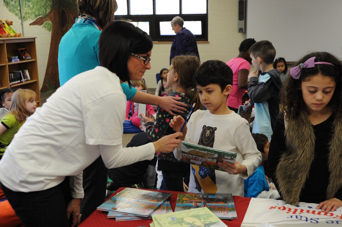 First graders at Ashurst Elementary School aboard Marine Corps Base Quantico line up to receive a book, bookmark and pencil from the staff and volunteers of Blue Star Families, the organization that runs the Books on Bases program, which donated 90 books to the school.