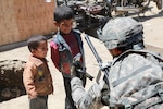 U.S. Army Capt. Stephen Iaquinto from Berlin, N.J., and a member of the 86th Infantry Brigade Combat Team, shows Afghan children a picture from his camera that he took of them. Members from Task Force Wolverine conducted a dismounted patrol through the Bagram Bazaar to find out information from the recent attack on Bagram Airfield, Parwan province, Afghanistan, May 24.