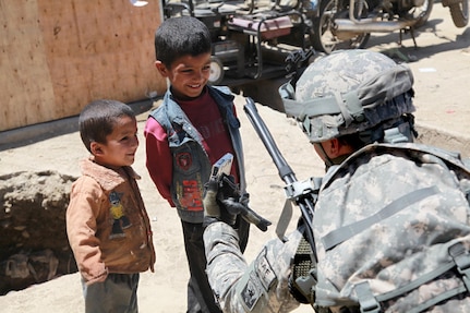 U.S. Army Capt. Stephen Iaquinto from Berlin, N.J., and a member of the 86th Infantry Brigade Combat Team, shows Afghan children a picture from his camera that he took of them. Members from Task Force Wolverine conducted a dismounted patrol through the Bagram Bazaar to find out information from the recent attack on Bagram Airfield, Parwan province, Afghanistan, May 24.