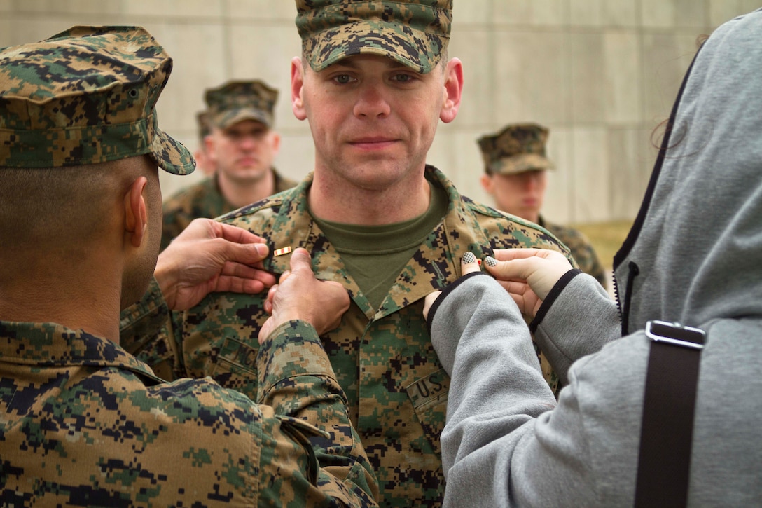 U.S. Marine Corps Chief Warrant Officer 2 Douglas McGlothlin is promoted to his present rank by his wife, Tiffany, and the executive officer of Recruiting Station Baltimore, Capt. Rineet Rajan at the National Museum of the Marine Corps, Feb. 5, 2015. McGlothlin, a native of Waldorf, Maryland, enlisted in the Marine Corps 15 years ago and achieved the rank of gunnery sergeant prior to being appointed a chief warrant officer 2.(U.S. Marine Corps photo by Sgt. Bryan Nygaard/Released