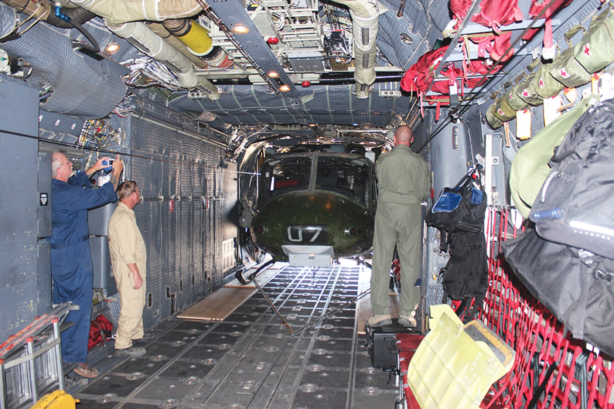 A Huey is loaded into the cargo bay of an MC-130H to be delivered to Kirtland. The helicopter was a tight fit, coming within inches of the top and sides of the cargo bay, according to the fabricators at the 58th Training Squadron. The Huey will be used for training and is expected to save the military roughly $1 million a year, (Photo by Lee Ross)