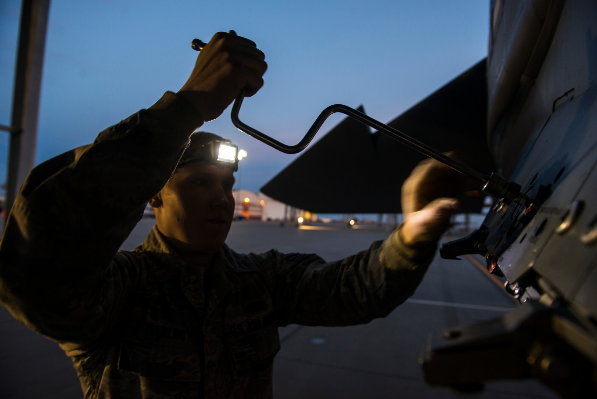 Senior Airman Trevor Darling, 391st Bold Tigers weapons loadcrew member, adjusts a mount on an F-15E Strike Eagle Feb. 19, 2015 at Mountain Home Air Force Base, Idaho. The older Light-All lamps supplied inadequate lighting on the flightline, forcing Airmen to use headlamps and flashlights to assist them in daily duties. Recently added overhead lights have helped to alleviate these poor lighting issues.(U.S. Air Force photo by Airman Connor J. Marth/RELEASED)