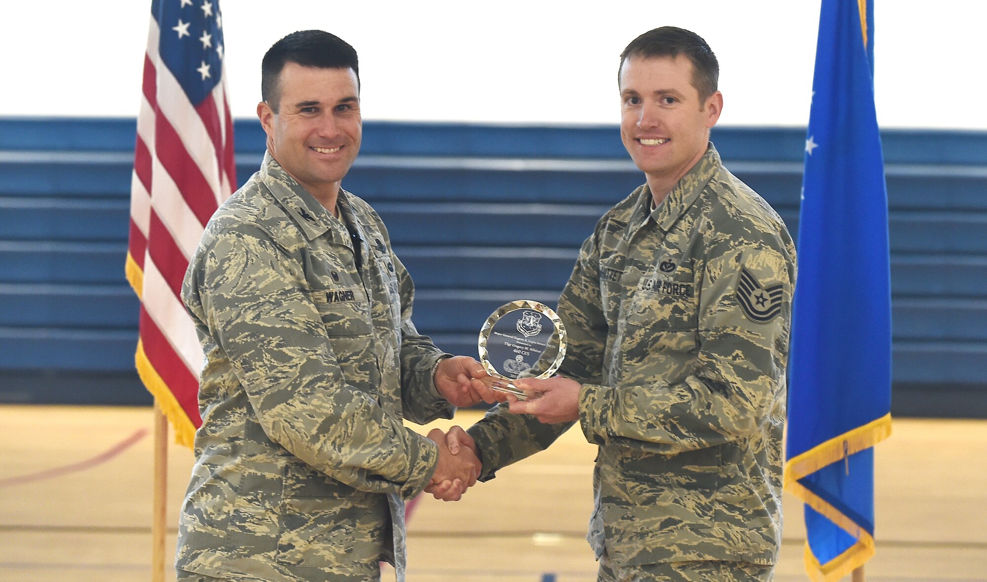 Col. John Wagner, 460th Space Wing commander, presents the Maj. Gen. Eugene A. Lupia Award to Tech. Sgt. Gregory M. Whittet, 460th Civil Engineering Squadron acting first sergeant, Feb. 19, 2015, at Buckley Air Force Base, Colo. Whittet received the award for his job performance and leadership. (U.S. Air Force photo by Airman 1st Class Luke W. Nowakowski/Released)