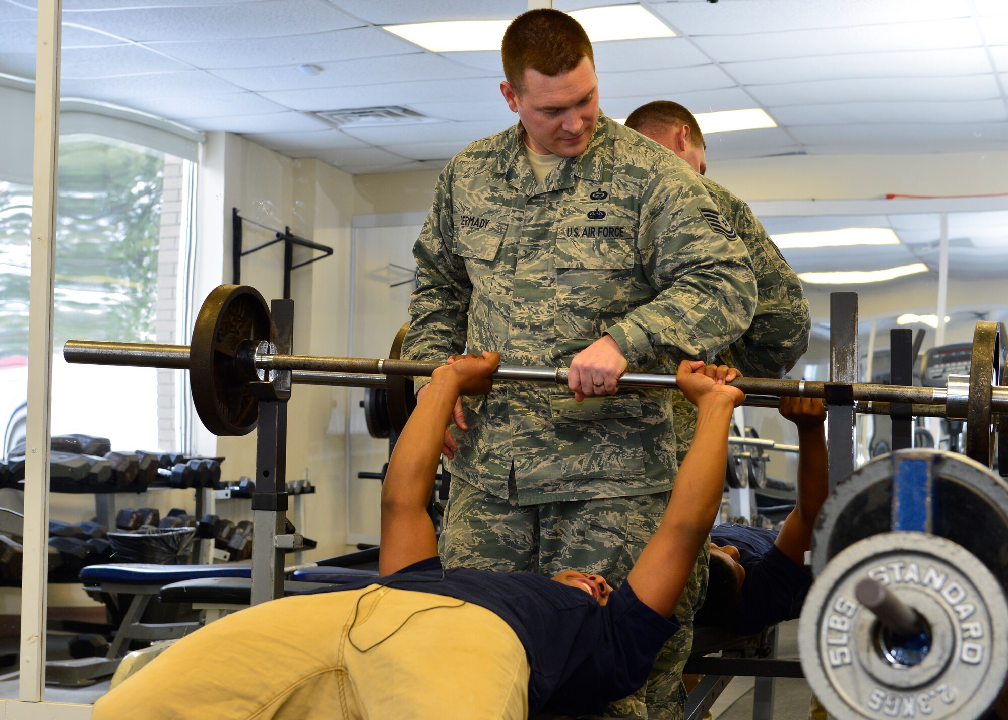 Tech. Sgt. Patrick Dermady, 436th Operations Support Squadron Intelligence Flight chief, assists Jawann Butcher, 14, bench press, Feb. 19, 2015, at the Kent County Secondary Intensive Learning Center, in Dover, Del. Dermady has been mentoring Butcher for the past five months. (U.S. Air Force photo/Airman 1st Class Zachary Cacicia)