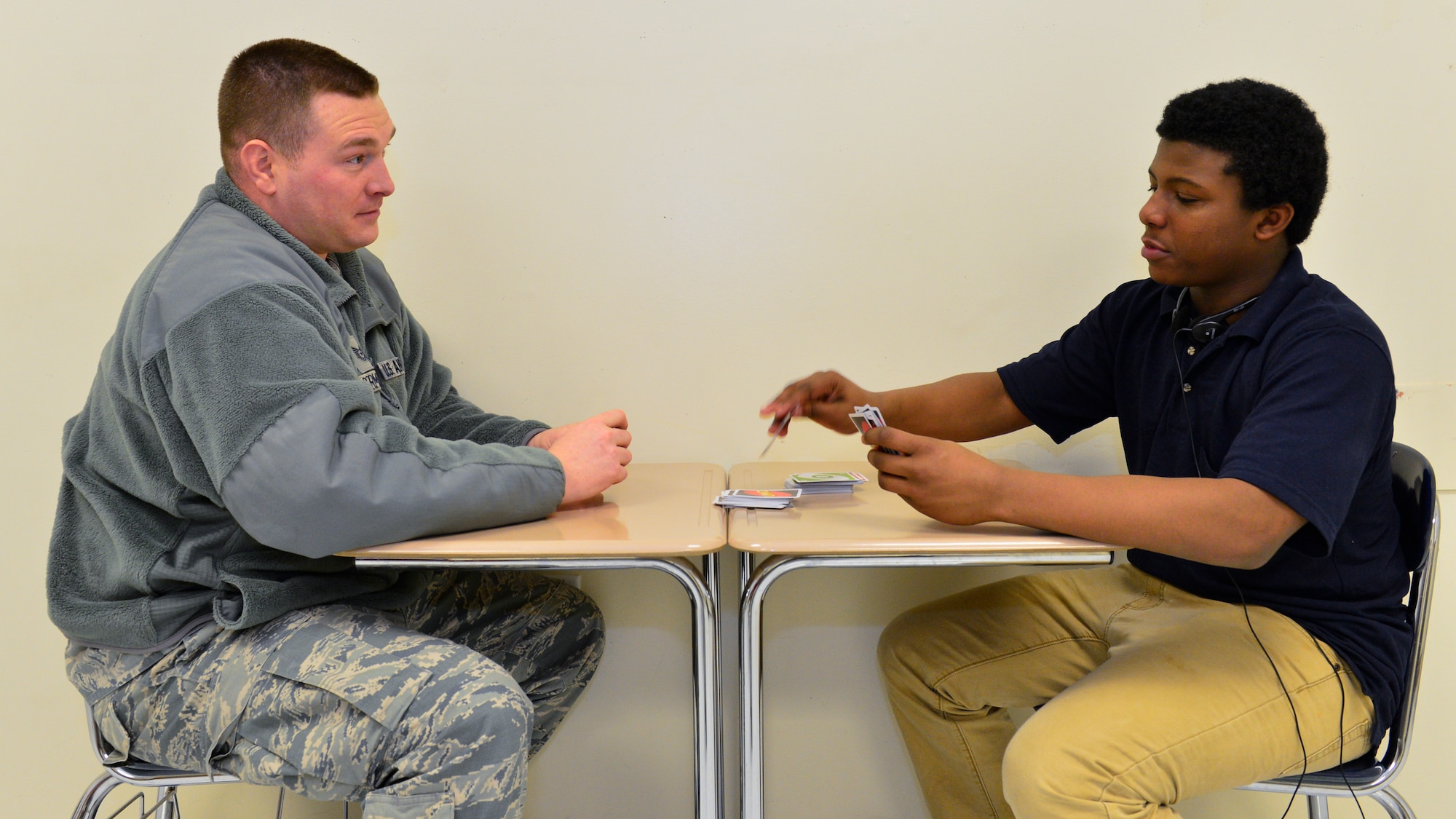 Tech. Sgt. Patrick Dermady, 436th Operations Support Squadron Intelligence Flight chief, and Jawann Butcher, 14, play the card game, Uno, Feb. 19, 2015, at the Kent County Secondary Intensive Learning Center, in Dover, Del. Dermady, visits with Butcher, an 8th Grade student, to mentor once a week. (U.S. Air Force photo/Airman 1st Class Zachary Cacicia)