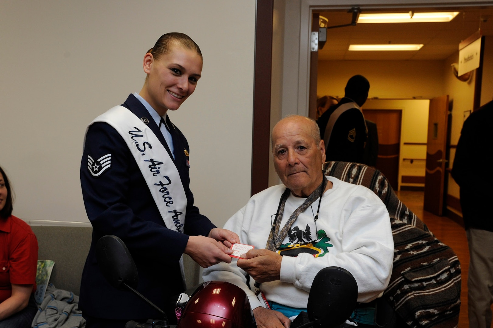 Air Force Staff Sgt. Stephanie Hall, 2015 Joint Base San Antonio military ambassador, hands a valentine to Alfredo Espinosa during the 2015 National Salute to Veteran Patients program Feb. 13 at the Audie L. Murphy Memorial Veterans Hospital. (U.S. Air Force photo by Harold China)