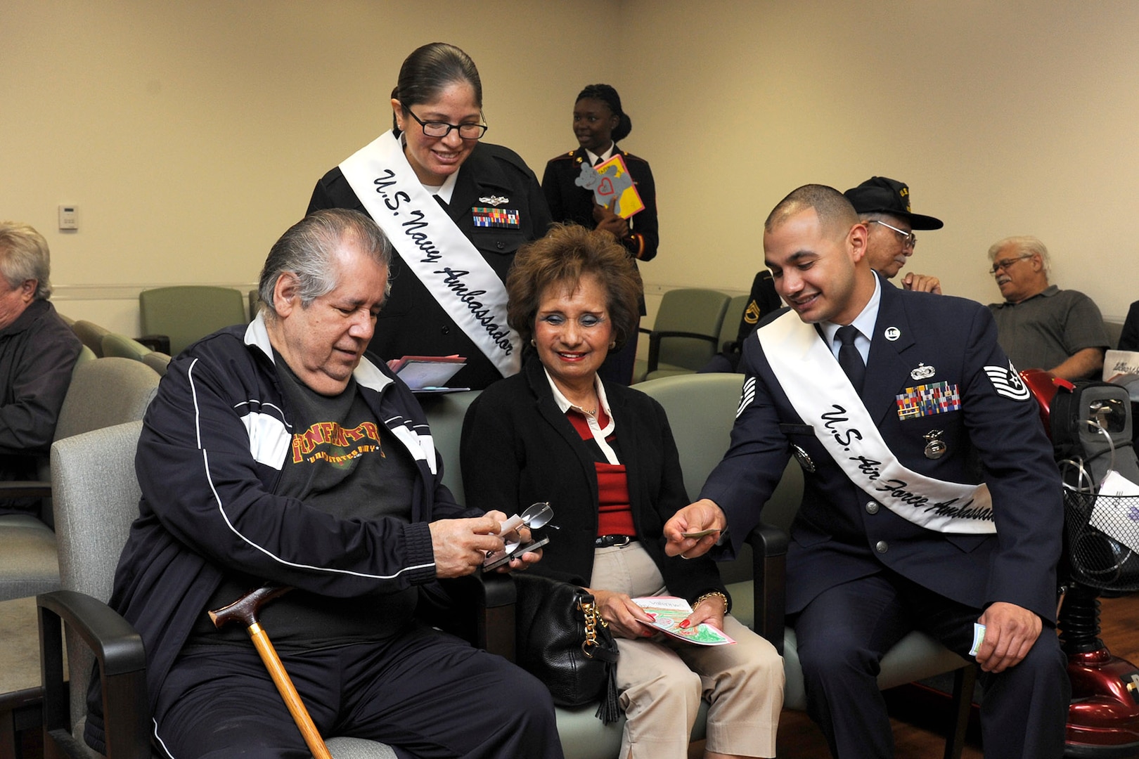 Navy Petty Officer 2nd Class Shantal Zavala (standing) and Air Force Tech. Sgt. Juan Flores (right), 2015 Joint Base San Antonio military ambassadors, speak to Frank and Irma Mercado during the 2015 National Salute to Veteran Patients program Feb. 13 at Audie L. Murphy Memorial Veterans Hospital. (U.S. Air Force photo by Harold China)