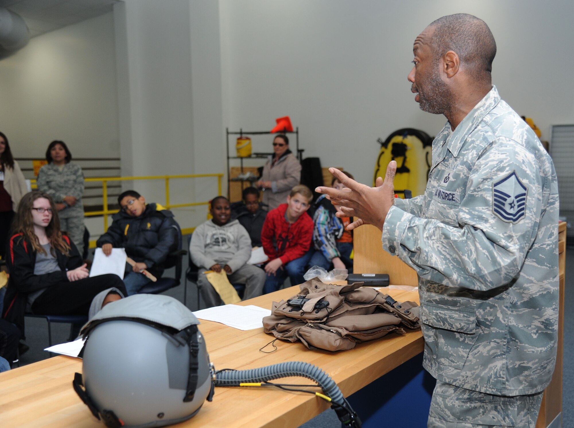 Master Sgt. Ray Reynolds, 403rd Operations Support Squadron aircrew flight equipment NCO in charge, briefs school-aged children on air crew flight equipment during Biloxi Career Exploration Day Feb. 19, 2015, outside the weather complex, Keesler Air Force Base, Miss.  The children also toured the 334th Training Squadron, the 335th TRS, the 81st Security Forces Squadron canine facility and the Keesler Fire Department.  (U.S. Air Force photo by Kemberly Groue)