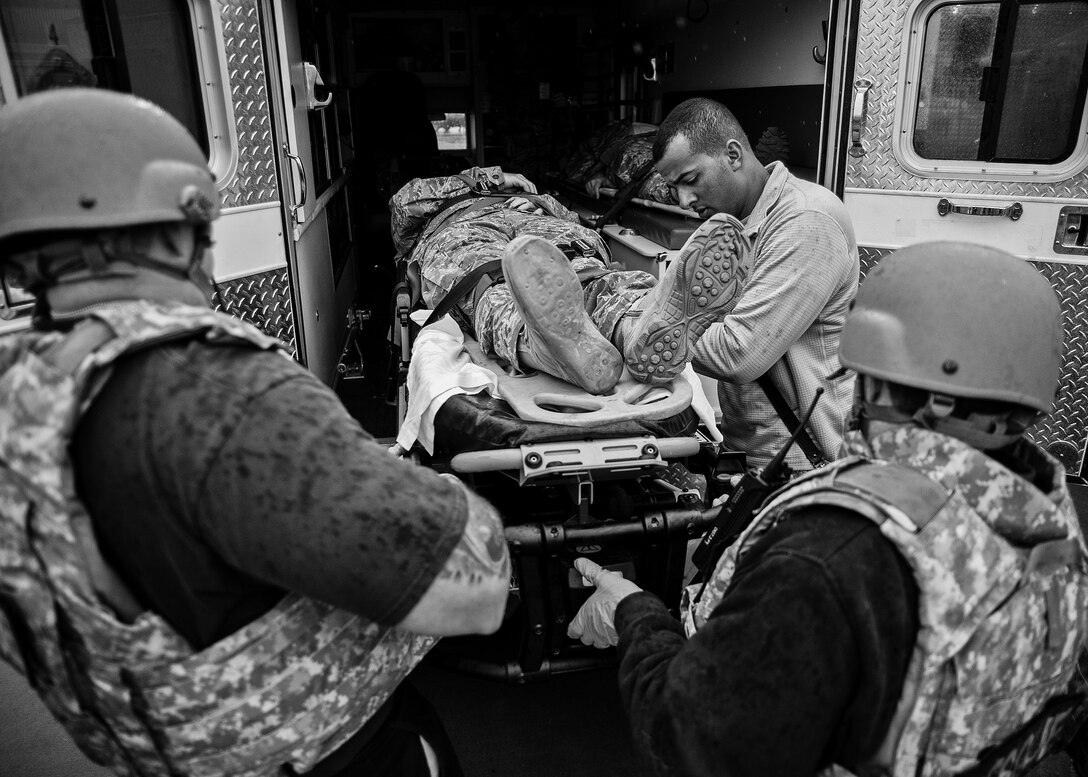 Medical technicians and firefighters move a simulated gunshot victim with a spinal injury onto an ambulance during an active shooter exercise Feb. 4 at Duke Field, Fla. Upon the all clear notification from security forces, the first responders entered the building to take care of the wounded victims. (U.S. Air Force photo/Tech. Sgt. Samuel King)