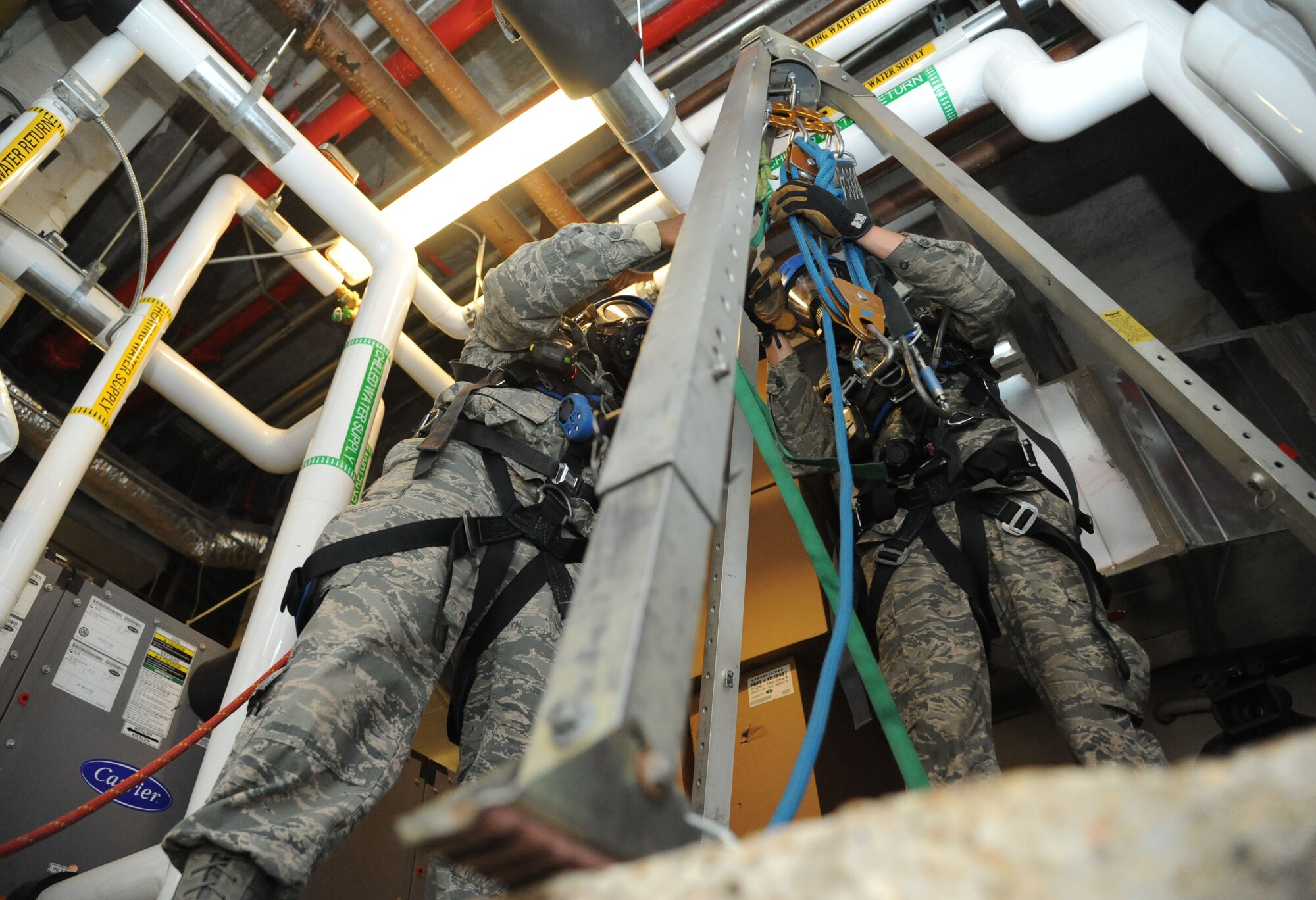 Two students assemble a tripod during confined space rescue operations training Feb. 13, 2015, at the Medical Center, Keesler Air Force Base, Miss.  Keesler hosted the one-time advanced rescue certification training course, which consisted of confined space rescue, high and low angle rescue and stokes basket rescue operations.  Eleven students from four bases completed the course.  (U.S. Air Force photo by Kemberly Groue)