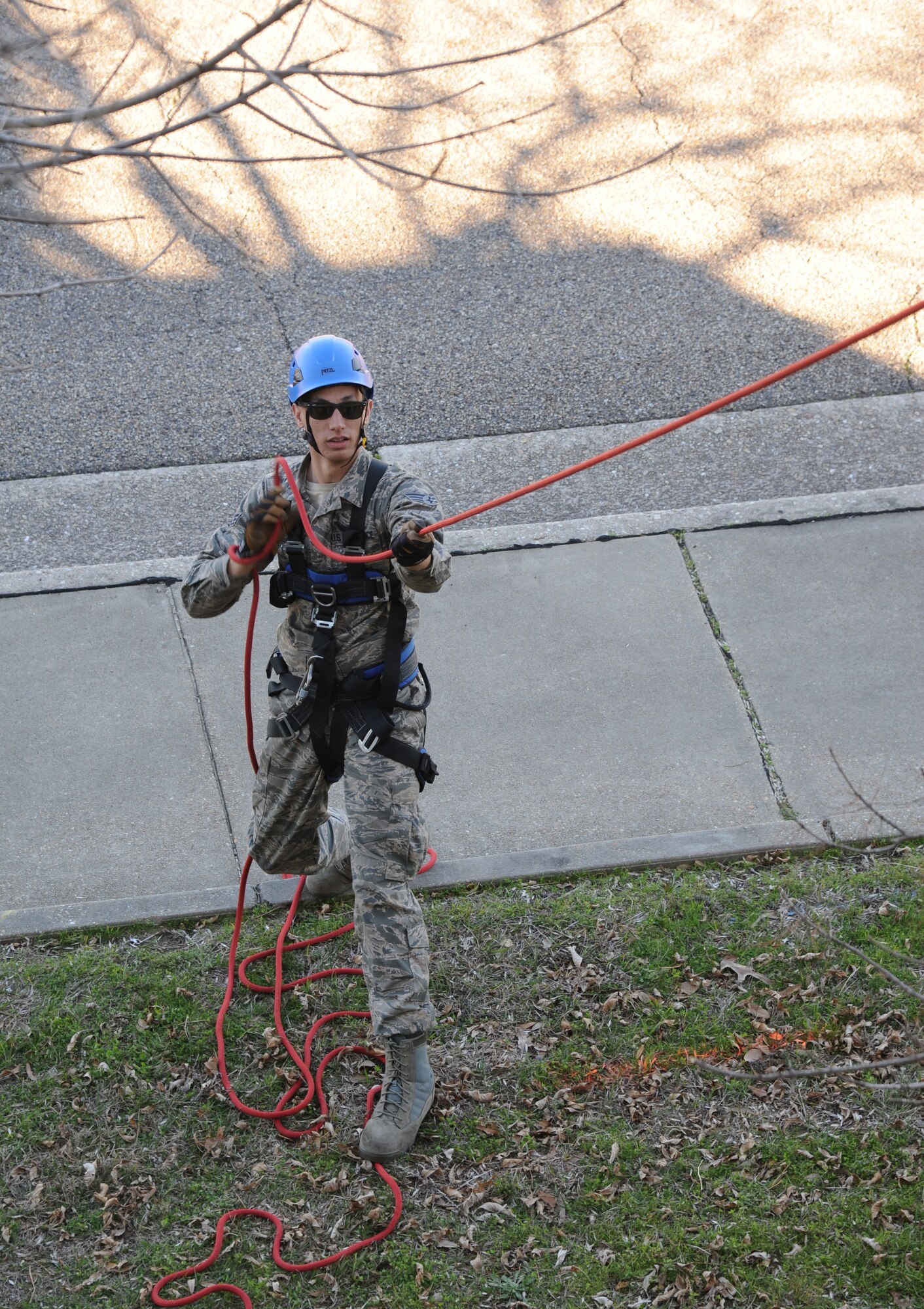 Senior Airman Kameron Scott, 14th Civil Engineering Squadron, Columbus Air Force Base, Miss., utilizes a tag line to keep a litter and rescuer from becoming caught or stuck on obstacles during basket lower rescue operations training Feb. 6, 2015, at Keesler Air Force Base, Miss.  Keesler hosted the one-time advanced rescue certification training course, which consisted of confined space rescue, high and low angle rescue and stokes basket rescue operations.  Eleven students from four bases completed the course.  (U.S. Air Force photo by Kemberly Groue)