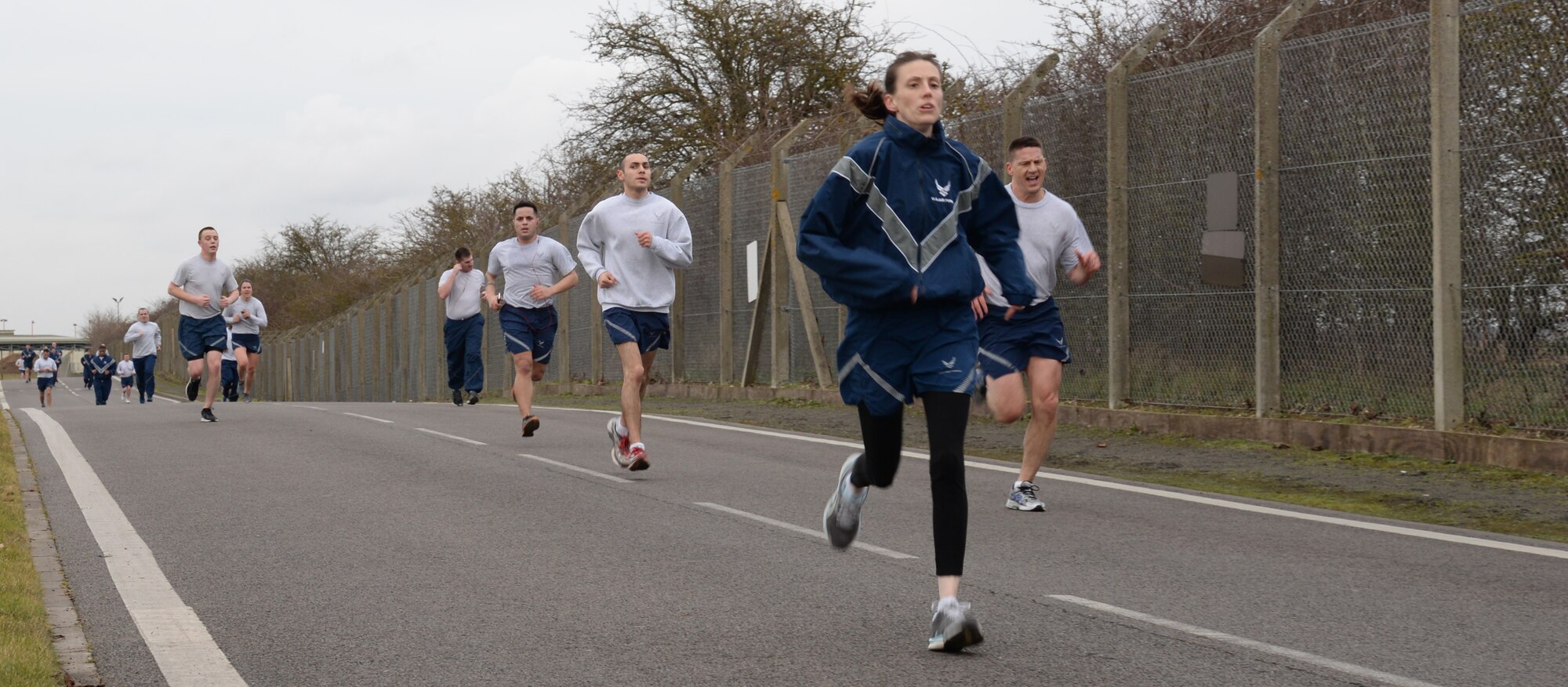 With the finish in sight, Team Mildenhall members sprint the last leg of a wing run Feb. 20, 2015, on RAF Mildenhall, England. The monthly 5 km run encourages morale and camaraderie through exercise and healthy competition. (U.S. Air Force photo by Airman 1st Class Jonathan Light/Released) 