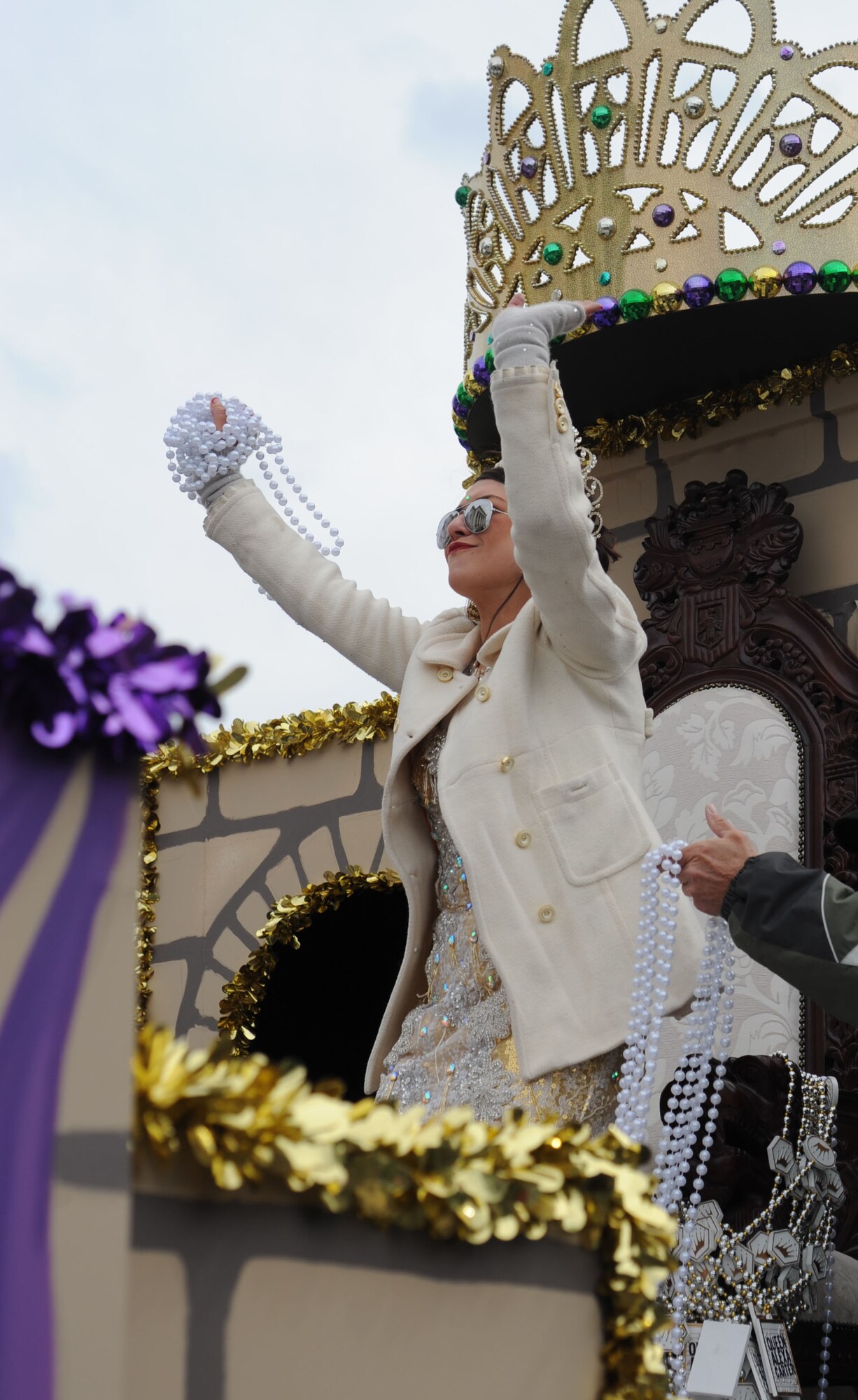 Alexa Carter, Queen Ixolib , prepares to throw strands of beads to the audience during the Gulf Coast Carnival Association Mardi Gras parade Feb. 17, 2015, in Biloxi, Miss.  The Keesler Honor Guard led the parade and base leadership attended the event.  (U.S. Air Force photo by Kemberly Groue)