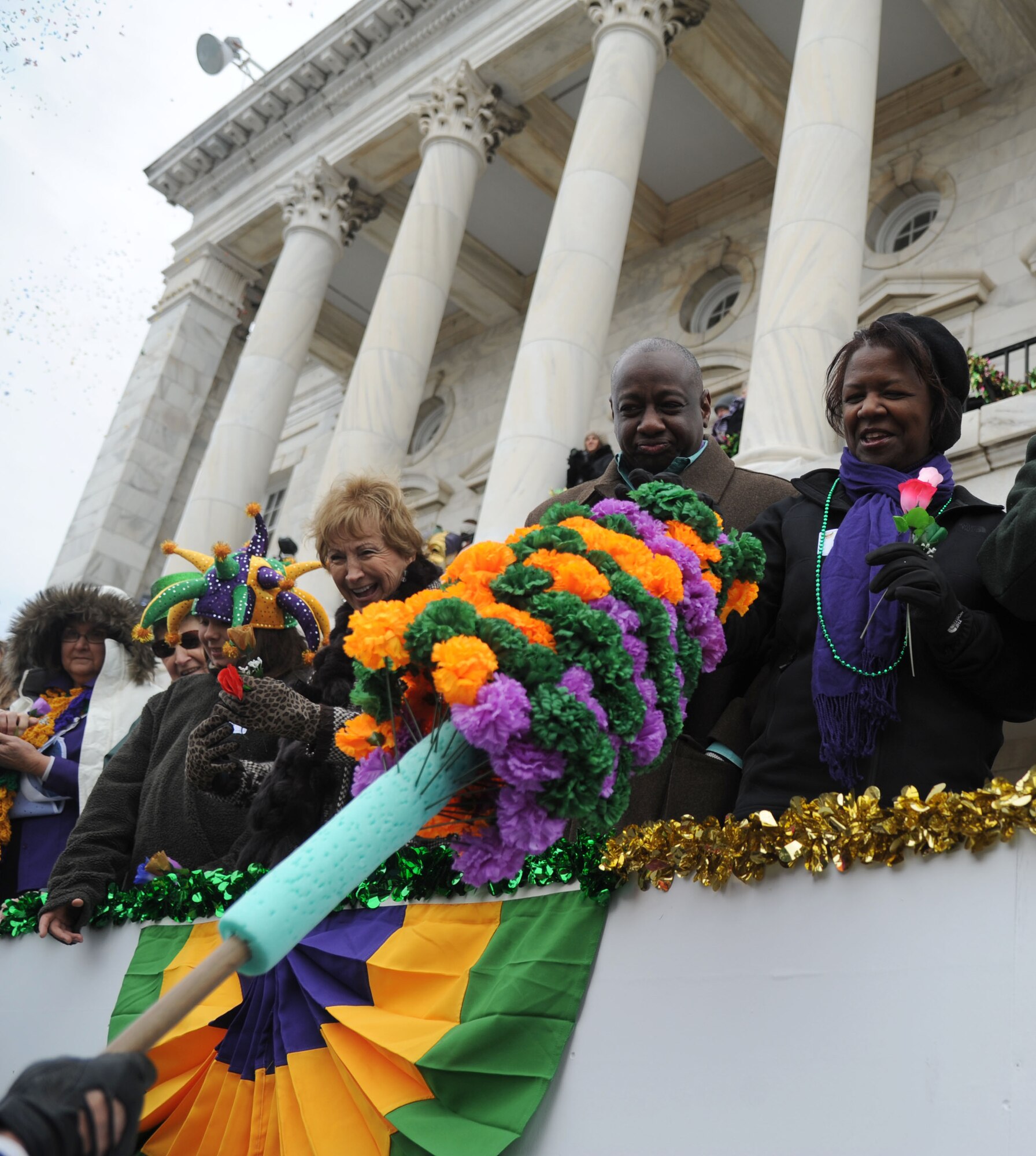 Maj. Gen. Mark Brown, 2nd Air Force commander, and his wife, Gwen, accept a paper flower during the Gulf Coast Carnival Association Mardi Gras parade Feb. 17, 2015, in Biloxi, Miss.  The Keesler Honor Guard led the parade and other base leadership also attended the event. (U.S. Air Force photo by Kemberly Groue)