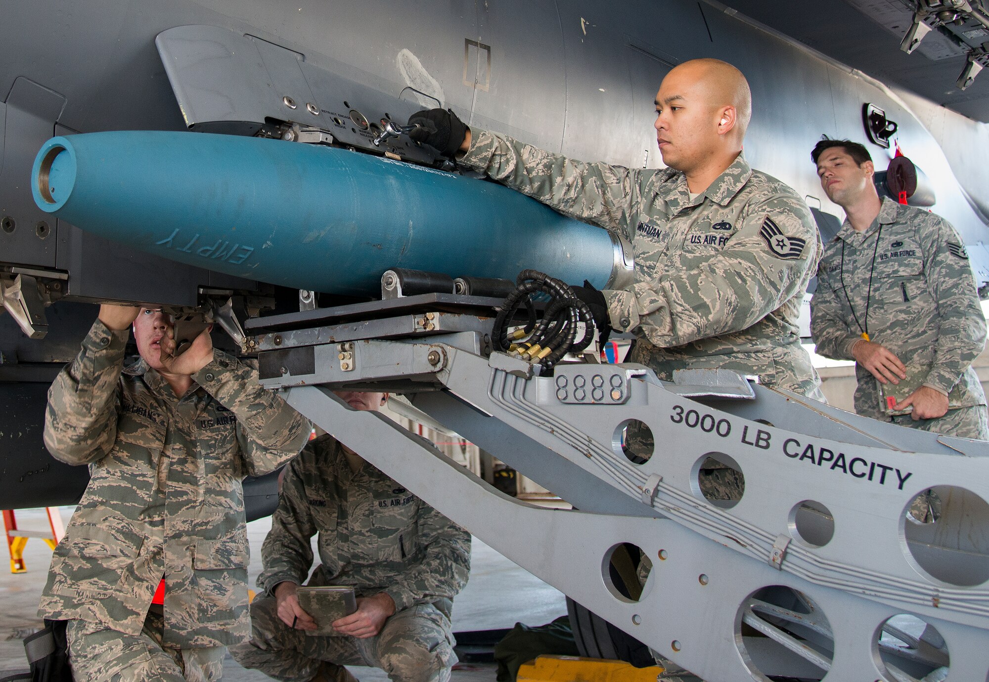 Airman 1st Class Vadim Milligan and Staff Sgt. Adrian Pamintuan, 96th Aircraft Maintenance Squadron, secure a guided bomb unit into place on an F-15 Eagle during the annual weapons load crew of the year competition Feb. 13 at Eglin Air Force Base, Fla.  Two F-16 Fighting Falcon and two F-15 teams loaded five weapons on their respective aircraft for the rights to be the load crew of the year for 2014.  The timed competition is judged on safety, speed and accuracy.  The winner of the competition will be announced at the 96th Maintenance Group’s annual awards banquet in March.  (U.S. Air Force photo/Tech. Sgt. Jasmin Taylor)