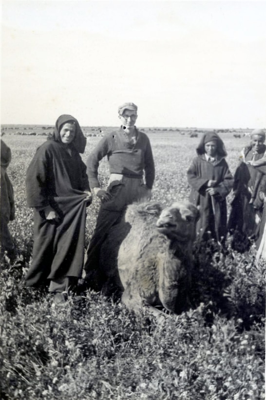 118th ACW Sq's John Randall standing behind camel with a local family (Photo by NCANG Heritage Program)