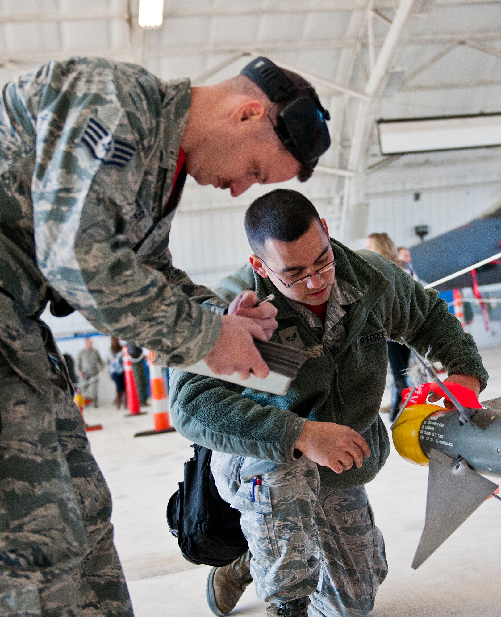 Staff Sgt. Stephen Presley and Senior Airman Christopher Mann, 96th Aircraft Maintenance Squadron, verify weapon information with their checklist during the annual weapons load crew of the year competition Feb. 13 at Eglin Air Force Base, Fla.  Two F-16 Fighting Falcon and two F-15 teams loaded five weapons on their respective aircraft for the rights to be the load crew of the year for 2014.  The timed competition is judged on safety, speed and accuracy.  The winner of the competition will be announced at the 96th Maintenance Group’s annual awards banquet in March.  (U.S. Air Force photo/Samuel King Jr.)
