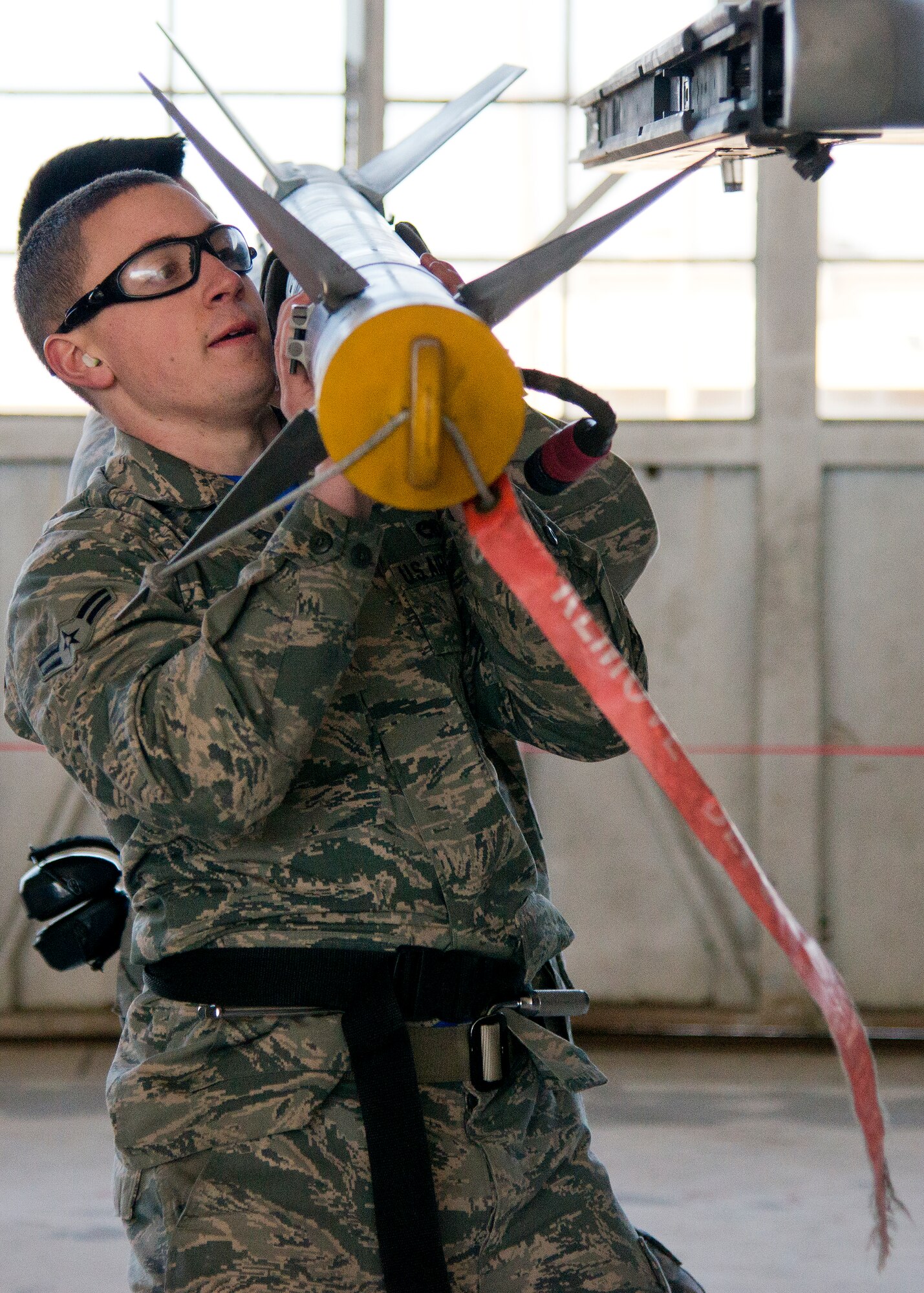 Airman 1st Class Trey Riley and a 96th Aircraft Maintenance Squadron F-16 Fighting Falcon Blue Team, carry an AIM-9X to their aircraft during the annual weapons load crew of the year competition Feb. 13 at Eglin Air Force Base, Fla.  Two F-16 and two F-15 Eagle teams loaded five weapons on their respective aircraft for the rights to be the load crew of the year for 2014.  The timed competition is judged on safety, speed and accuracy.  The winner of the competition will be announced at the 96th Maintenance Group’s annual awards banquet in March.  (U.S. Air Force photo/Tech. Sgt. Jasmin Taylor)