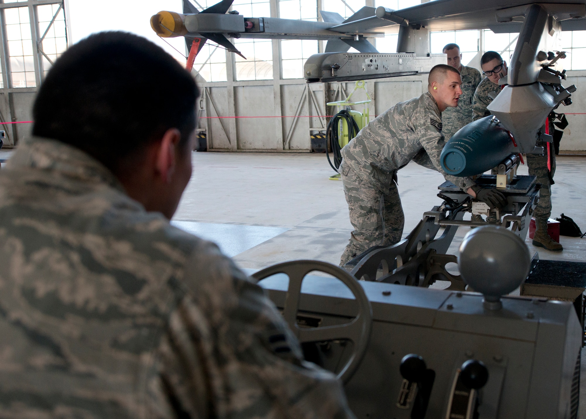 Staff Sgt. Brandon Oliver, 96th Aircraft Maintenance Squadron, sights in the placement of a guided bomb unit onto an F-16 Fighting Falcon during the annual weapons load crew of the year competition Feb. 13 at Eglin Air Force Base, Fla.  Two F-16 and two F-15 Eagle teams loaded five weapons on their respective aircraft for the rights to be the load crew of the year for 2014.  The timed competition is judged on safety, speed and accuracy.  The winner of the competition will be announced at the 96th Maintenance Group’s annual awards banquet in March.  (U.S. Air Force photo/Tech. Sgt. Jasmin Taylor)