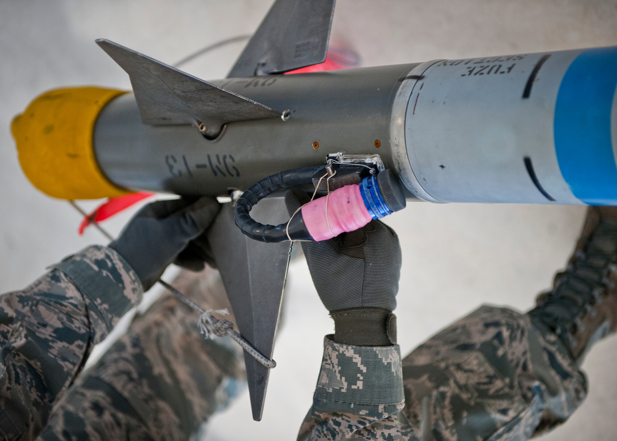 Airman 1st Class Troy Carpenter, 96th Aircraft Maintenance Squadron, adjusts the fin on an AIM-9X missile prior to placing it on an F-16 Fighting Falcon during the annual weapons load crew of the year competition Feb. 13 at Eglin Air Force Base, Fla.  Two F-16 and two F-15 Eagle teams loaded five weapons on their respective aircraft for the rights to be the load crew of the year for 2014.  The timed competition is judged on safety, speed and accuracy.  The winner of the competition will be announced at the 96th Maintenance Group’s annual awards banquet in March.  (U.S. Air Force photo/Samuel King Jr.)