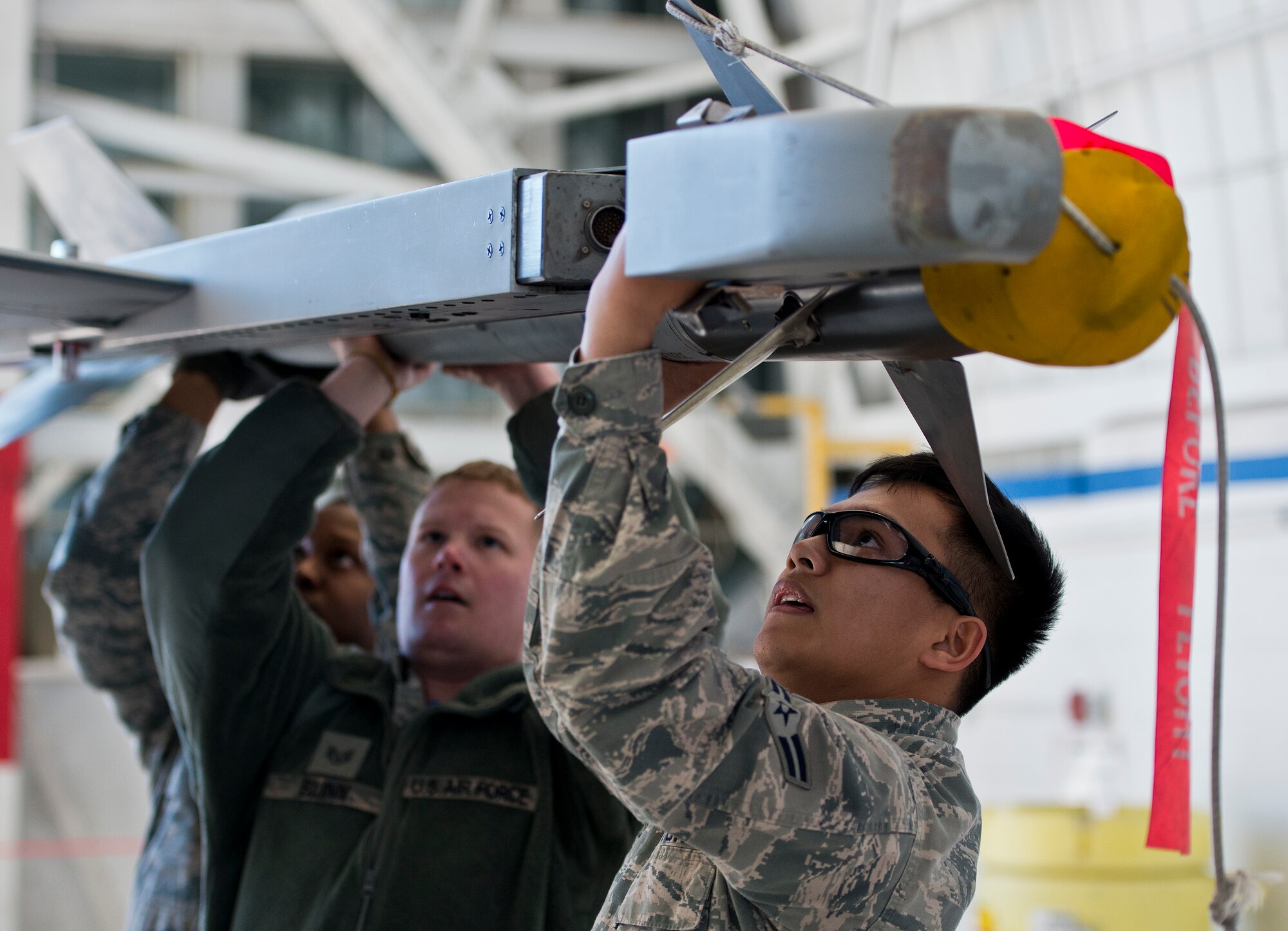A 96th Aircraft Maintenance Squadron Blue F-16 Fighting Falcon team lifts up an AIM-9X missile onto their aircraft during the annual weapons load crew of the year competition Feb. 13 at Eglin Air Force Base, Fla.  Two F-16 and two F-15 Eagle teams loaded five weapons on their respective aircraft for the rights to be the load crew of the year for 2014.  The timed competition is judged on safety, speed and accuracy.  The winner of the competition will be announced at the 96th Maintenance Group’s annual awards banquet in March.  (U.S. Air Force photo/Samuel King Jr.)