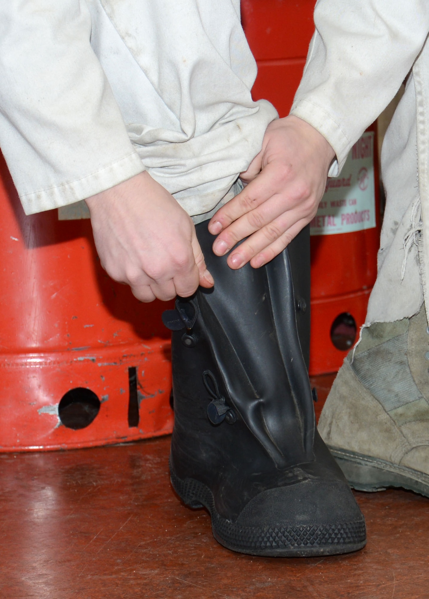 U.S. Air Force Senior Airman Matthew Dillard, 100th Logistics Readiness Squadron cryogenic specialist from Las Vegas, Nev., secures his safety footwear prior to draining pressure on the main liquid oxygen storage tank Feb. 11, 2015, on RAF Mildenhall, England. Correct personal protective equipment is vital to Airmen working with fuel and liquid oxygen. (U.S. Air Force photo by Gina Randall/Released)