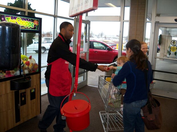 Marine 2nd Lt. Daryl J. Scales lets a child play with a Salvation Army bell while volunteering at a supermarket. Scales is a University of Missouri graduate who enjoys serving his country and volunteering to support the local community. 