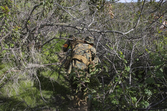Recruits Jacob R. Kottman and Chainey L. Ellis, (left to right) Platoon 2105, Echo Company, 2nd Recruit Training Battalion, make their way through brush during the Land Navigation Course at Edson Range, Marine Corps Base Camp Pendleton, Calif., Jan. 22.  Once in the course, recruits found out quickly the techniques taught were vital to being successful in course navigation.
