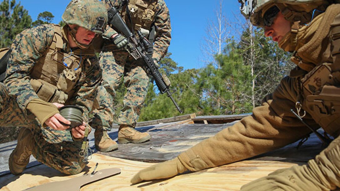 Marines with 2nd Combat Engineer Battalion set up an explosive charge on a rooftop during their urban breaching training exercise on Engineer Training Area-1 aboard Marine Corps Base Camp Lejeune, N.C., Feb. 19, 2015. During the training, the unit learned how to open any type of door, gate or roof using a variety of tools, from explosives to shotguns and sledge hammers. They learned to do whatever was necessary to allow the infantry squad they were supporting to enter the building.