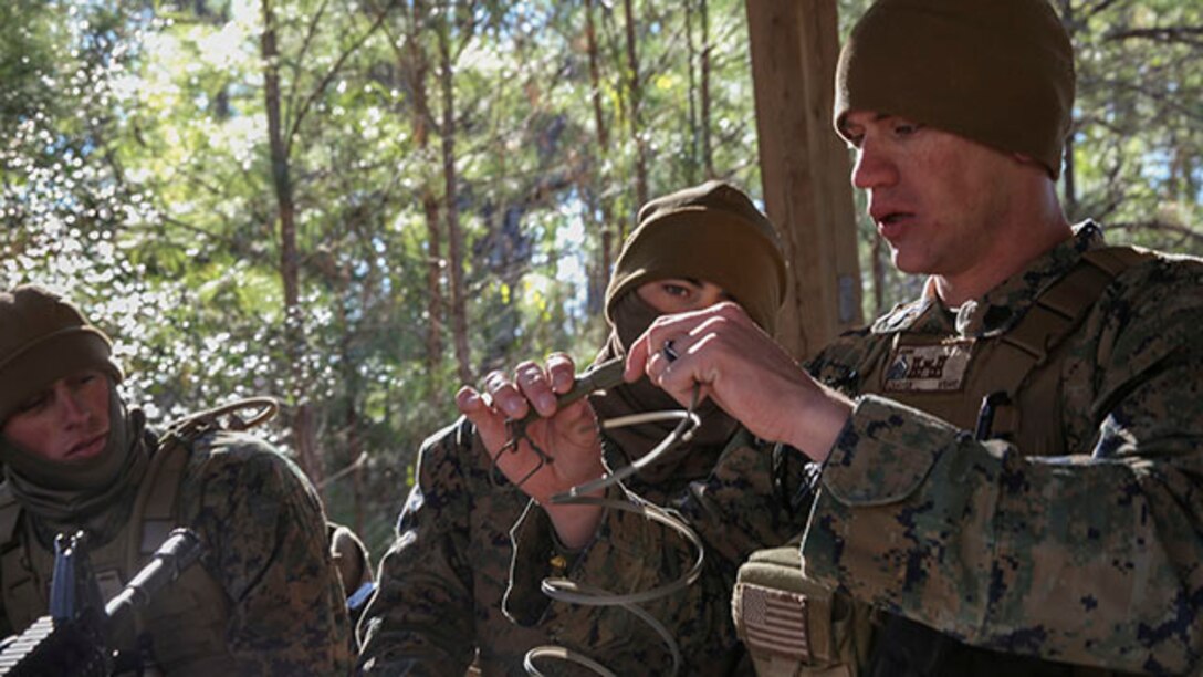 Sergeant Tyler Craven, a squad leader with 3rd platoon, 2nd Combat Engineer Battalion and native of Mebane, N.C., instructs his fire team on how to build an explosive charge during urban breaching training on Engineer Training Area-1 aboard Marine Corps Base Camp Lejeune, N.C., Feb. 19, 2015. During the training, the unit learned how to open any type of door, gate or roof using a variety of tools, from explosives to shotguns and sledge hammers. They learned to do whatever was necessary to allow the infantry squad they were supporting to enter the building.