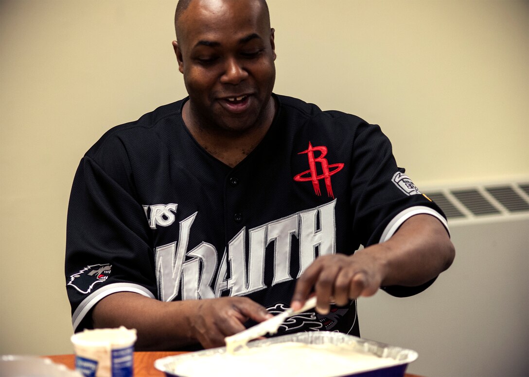 Staff Sgt. Lawyer Evans, 8th Logistics Readiness Squadron supply technician assistant NCO in charge, also known as “Cake Boss,” spreads cream cheese frosting on a red velvet cake Feb. 17, 2015, at Kunsan Air Base, Republic of Korea. Evans cooks more than a dozen cakes every month for individuals, organizations and events, including promotion celebrations, squadron barbecues and birthdays. (U.S. Air Force photo by Senior Airman Katrina Heikkinen/Released)