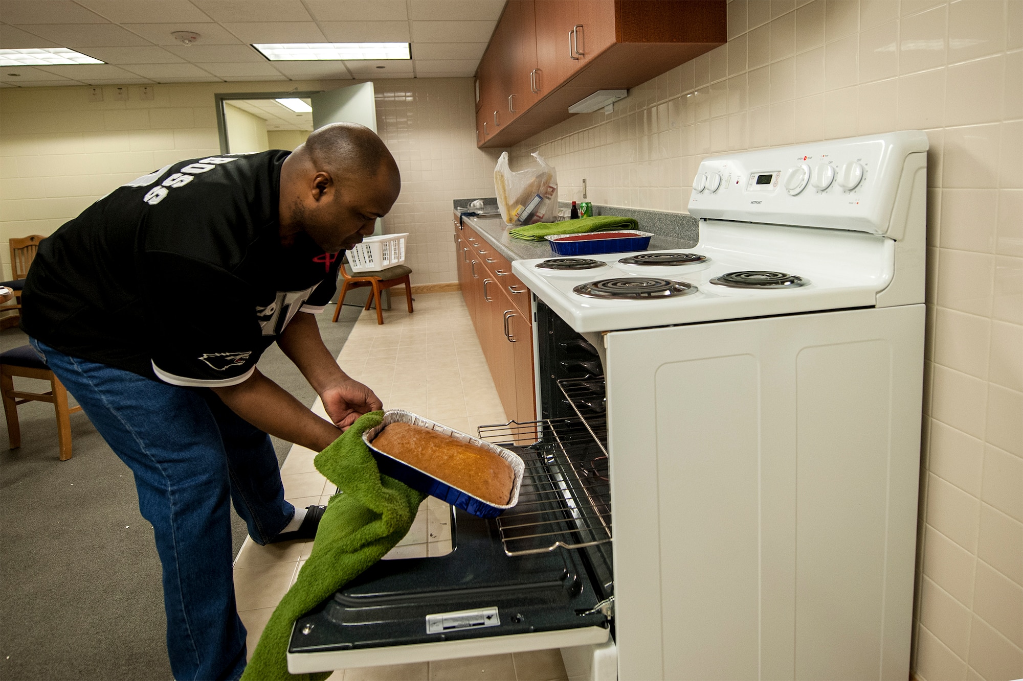 Staff Sgt. Lawyer Evans, 8th Logistics Readiness Squadron supply technician assistant NCO in charge, also known as “Cake Boss,” puts a cake into an oven Feb. 17, 2015, at Kunsan Air Base, Republic of Korea. Evans cooks more than a dozen cakes every month for individuals, organizations and events, including promotion celebrations, squadron barbecues and birthdays. (U.S. Air Force photo by Senior Airman Katrina Heikkinen/Released)