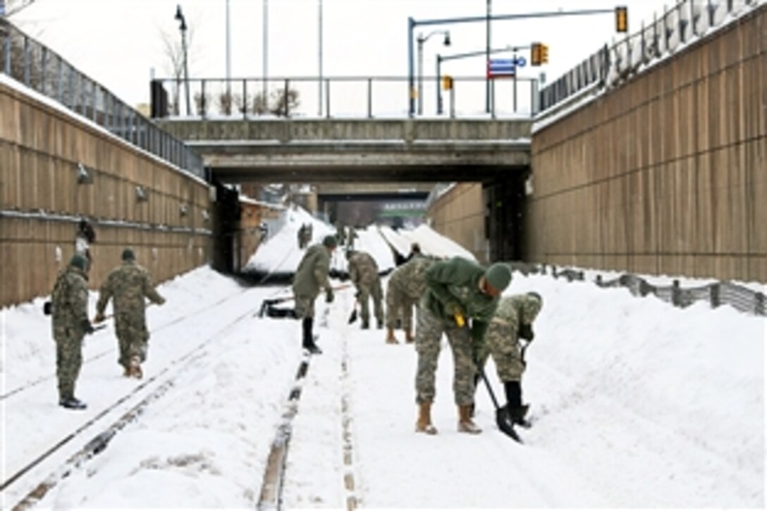 Soldiers help the Massachusetts Bay Transportation Authority remove snow at a train stop in Boston, Mass., Feb. 19, 2015. The soldiers are assigned to the Massachusetts National Guard's Company G, 186th Brigade Support Battalion.