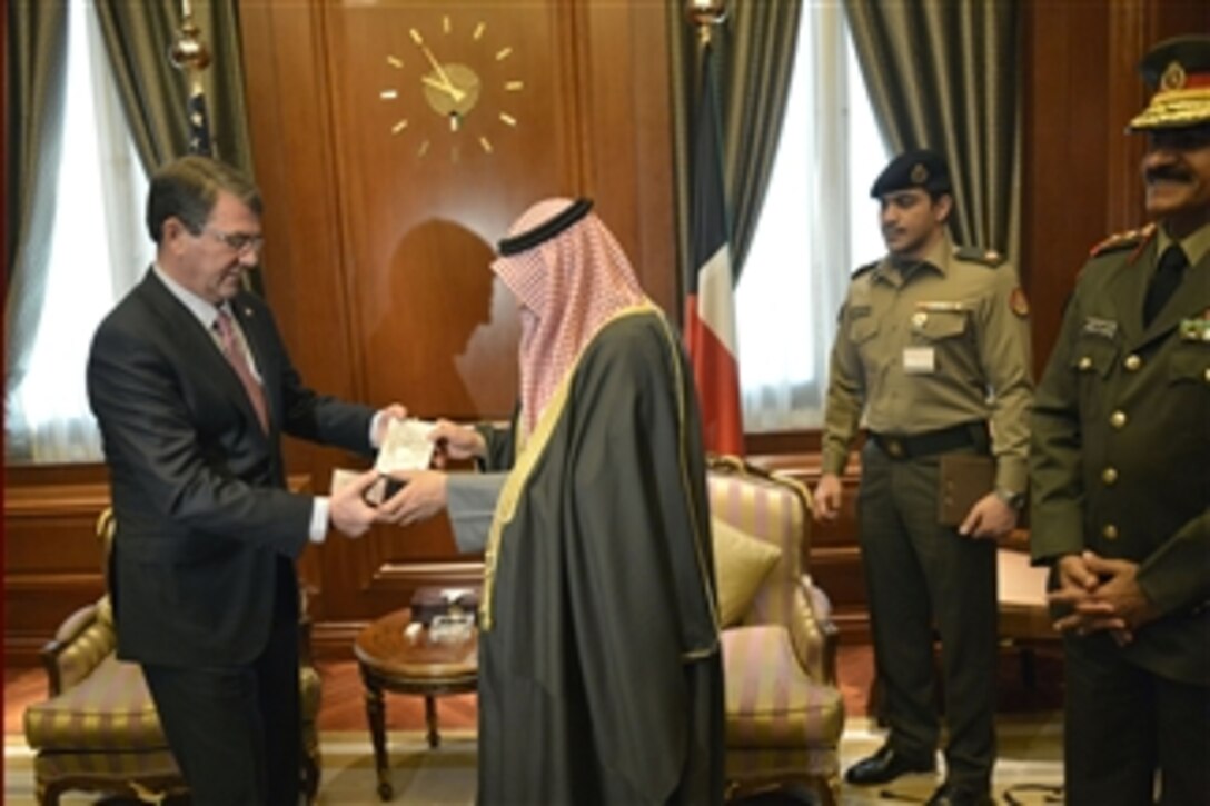 Defense Secretary Ash Carter, left, presents a gift to Kuwait's Deputy Prime Minister and Defense Minister Sheikh Khaled al-Jarrah al-Sabah while meeting with senior Kuwaiti officials in Kuwait City, Feb. 23, 2015. 